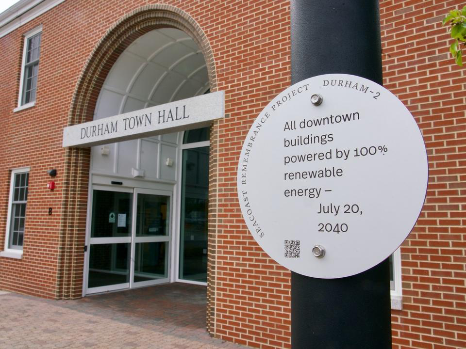A sign in front of Durham's Town Hall which reads