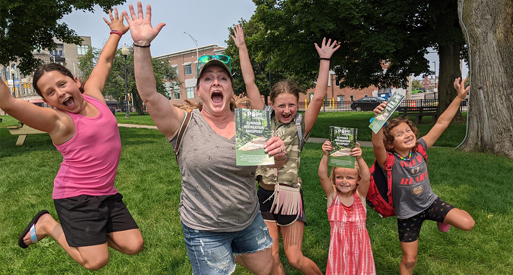 Family jumps in the air and shows of the Promoting Outdoor Play Summer Recreations Passports