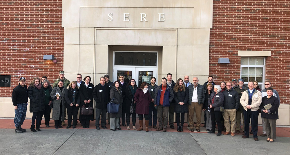 A large group involved in the Shipyard Joint Land Use Study pose for a photo on base at the Portsmouth Naval Shipyard.