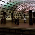 Photo from within a Metro tunnel in D.C. with green and purple lights reflected on the ceiling