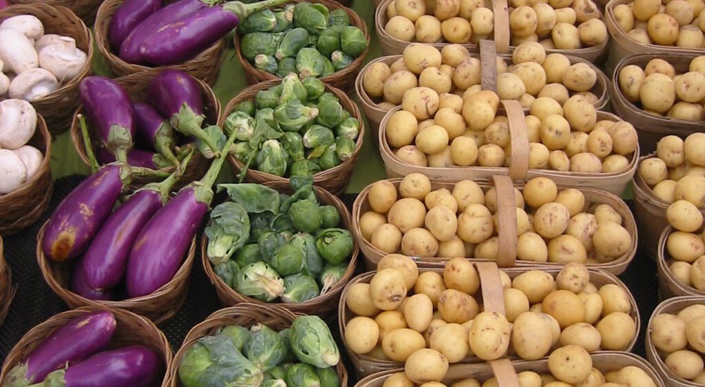 Farmer's market crops in baskets including mushrooms