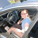 SRPC staffer Sarah McGraw poses in a tesla