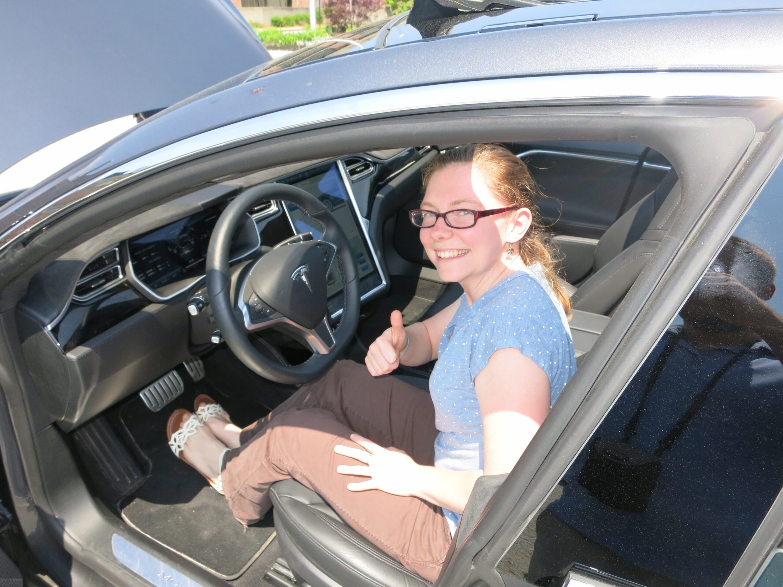 SRPC staffer Sarah McGraw poses in a tesla