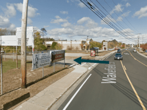 Streetscape showing the entrance to where SRPC is located, between a fence and bus shelter off of the pictured Wakefield St