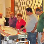 A group of citizens gathering around a flume display at a river workshop